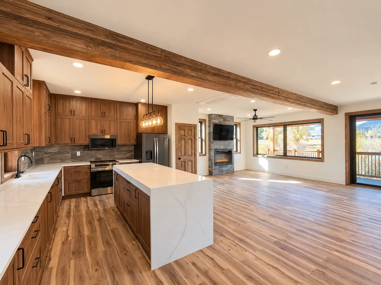 Kitchen with waterfall island, wood cabinetry and connected living area