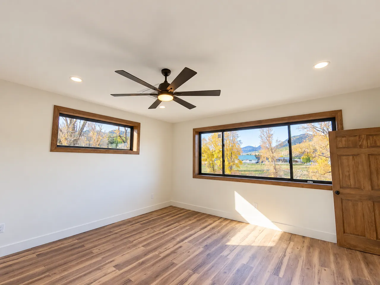 Upstairs primary bedroom with mountain outlook and ceiling fan